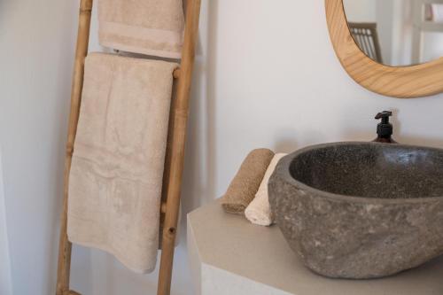 a bathroom with a stone sink and a mirror at TESORO Home & Spa in Plakias