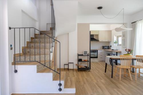 a living room and dining room with a staircase and a table at TESORO Home & Spa in Plakias