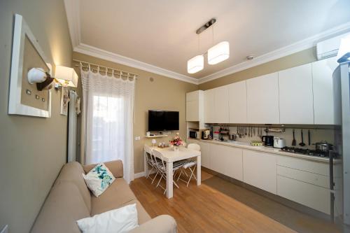 a kitchen and living room with a couch and a table at Charming and Cozy House in Nettuno