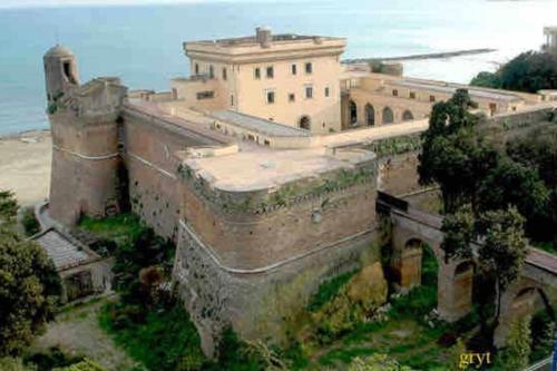 an old castle with a building on a hill at Charming and Cozy House in Nettuno