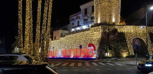 a building decorated with christmas lights at night at Charming and Cozy House in Nettuno