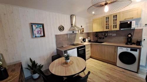 a kitchen with a wooden table and a small table with chairs at Apartment in Downtown in Châteaubriant