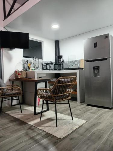 a kitchen with a table and a refrigerator at Casita Bohemia natural paradise in Peje Viejo
