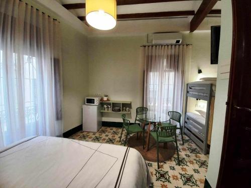 a bedroom with a bed and a table and chairs at La Casa del Médico in Pego