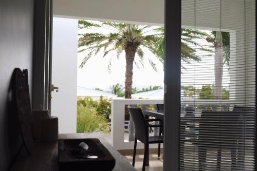 a living room with a view of a palm tree at Palm Crest in Willemstad