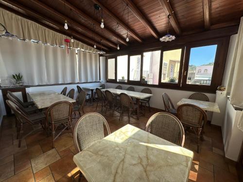 a dining room with tables and chairs and windows at Diana Brown B&B Affittacamere in Lipari