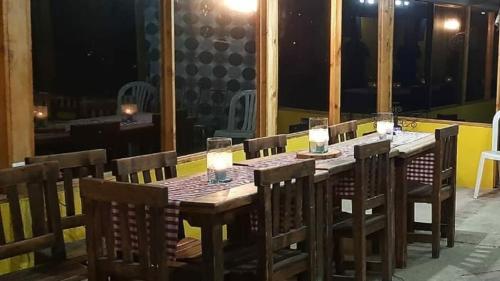 a wooden table with chairs and candles on a balcony at Casa de Campo Finca el Paraiso in Zipacón