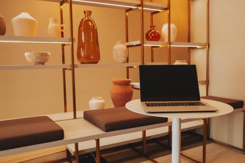 a laptop sitting on a table in a room with vases at Domum 4 in Porto