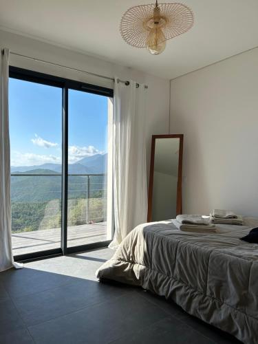 a bedroom with a bed and a large window at Villa H in Casanova