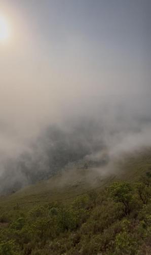 an aerial view of a foggy mountain with trees at Tranquil Retreat in Avathi