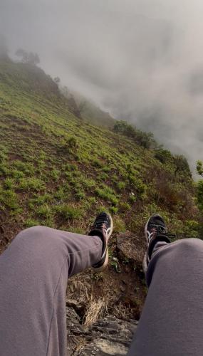 a person sitting on top of a hill with their feet up at Tranquil Retreat in Avathi