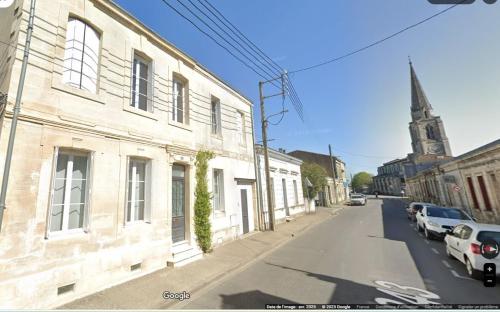 une rue vide avec un bâtiment et une église dans l'établissement chambre studio du logis du parc, à Libourne