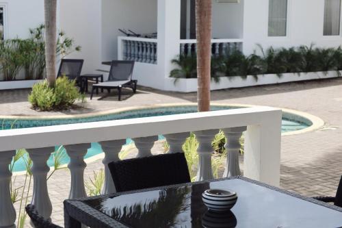 a balcony with a table and chairs and a pool at Palm Crest in Willemstad