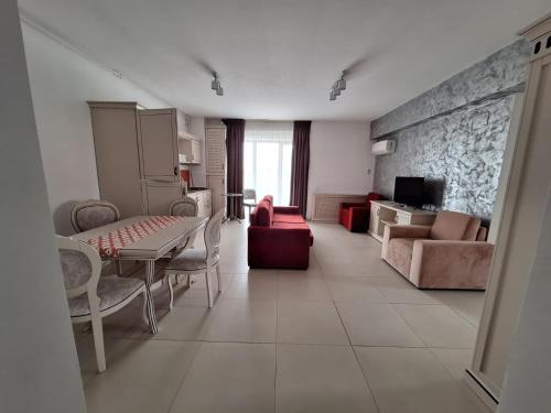 un salon avec un canapé, une table et des chaises dans l'établissement Miriam Apart, à Mamaia Nord – Năvodari