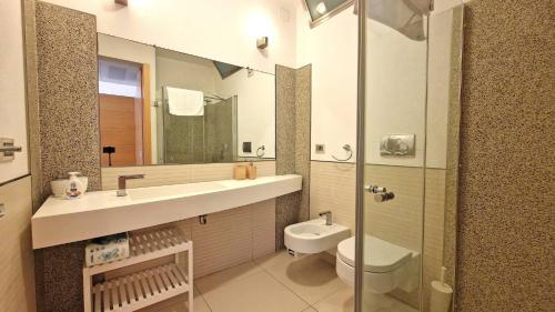 een badkamer met een wastafel, een toilet en een spiegel bij Suite la Giudecca by Salento Affitti in Gallipoli