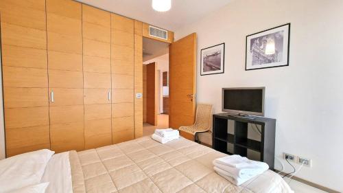 een slaapkamer met een bed en een televisie. bij Suite la Giudecca by Salento Affitti in Gallipoli