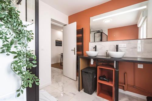 une salle de bain avec deux lavabos et un miroir dans l'établissement L'industriel - billard et home cinéma - hyper centre, à Reims