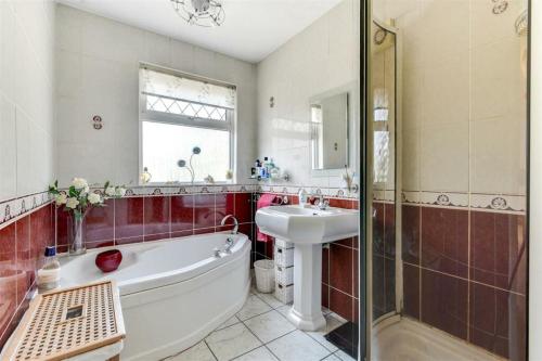 a bathroom with a tub and a sink and a shower at Westend House in Goring by Sea