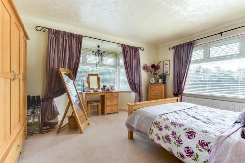 a bedroom with a bed and a desk and a window at Westend House in Goring by Sea