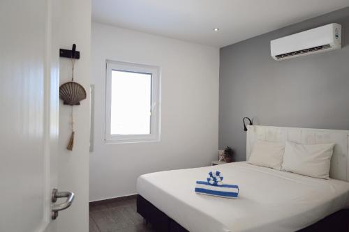 a white bedroom with a bed with a blue box on it at Palm Crest in Willemstad