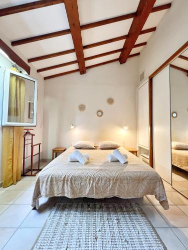 une chambre avec un grand lit dans une pièce dans l'établissement Maison Familiale à Sanary, en pleine pinède, à Sanary-sur-Mer