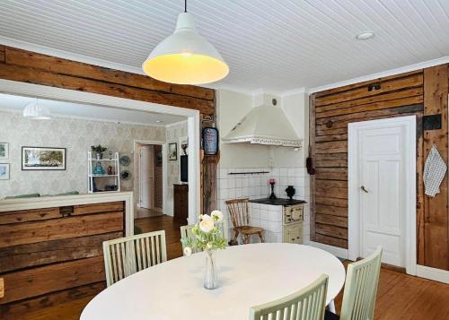 a kitchen and dining room with a white table and chairs at Fyra rum och kök i Mellanfjärden in Mellanfjärden