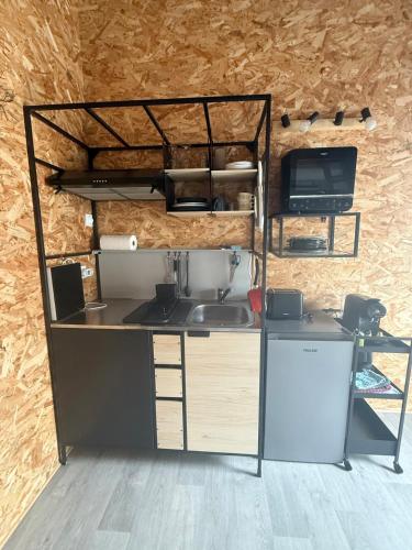 La cuisine est équipée d'un comptoir avec évier et d'un réfrigérateur. dans l'établissement Charmant Duplex, à Talence