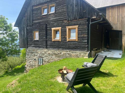 a black house with a bench in front of it at Künstlerstubn in Hartneidstein