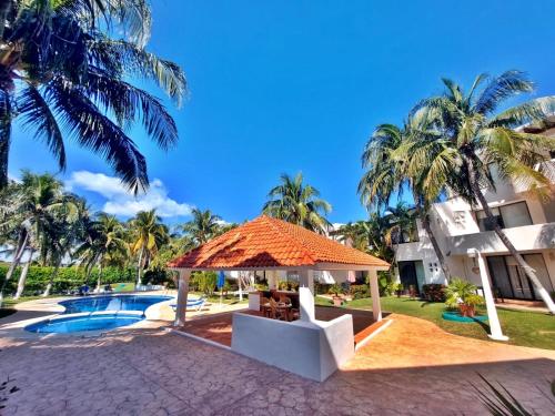 a resort with a swimming pool and palm trees at Hermosa planta baja con piscina, acceso a la Playa!!! in Cancún