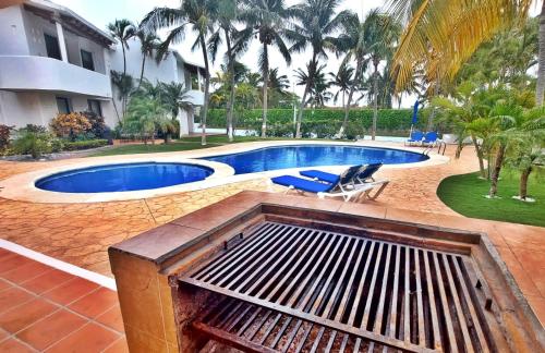 a swimming pool in front of a house at Hermosa planta baja con piscina, acceso a la Playa!!! in Cancún