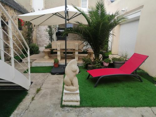 - un jardin avec une chaise rouge et un parasol dans l'établissement The Victory, à Bayeux