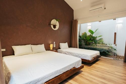 Un dormitorio con dos camas y una ventana. en Chian Homestay Hoa Lư, en Ninh Binh