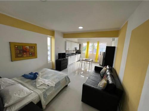 a bedroom with a bed and a couch and a kitchen at bavaro Punta Cana Beach club in Punta Cana