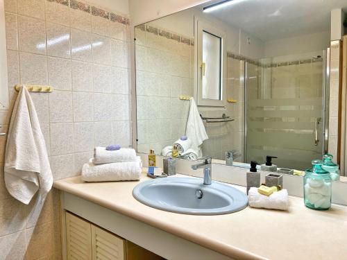 une salle de bain avec un lavabo et un miroir dans l'établissement Maison Familiale à Sanary, en pleine pinède, à Sanary-sur-Mer