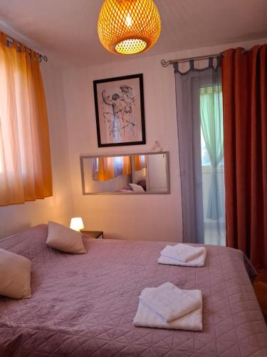 a bedroom with a large bed with two towels on it at Apartman Nenad in Pula