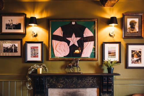 a fireplace in a room with pictures on the wall at Richard III Hotel in Middleham
