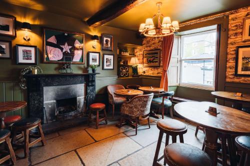 a bar with tables and chairs and a fireplace at Richard III Hotel in Middleham