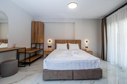 Un dormitorio con una cama grande y un escritorio. en Meraki Hospitality, en Polychrono