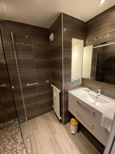 une salle de bain avec un lavabo et un miroir dans l'établissement Beau Studio dans résidence de standing avec 2 piscines proche des commerces, transport et plage, à Mandelieu-la-Napoule