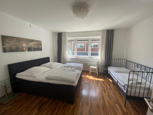 ein Schlafzimmer mit zwei Betten und einem Fenster in der Unterkunft XXL-Cologne Cathedral Apartment in Köln