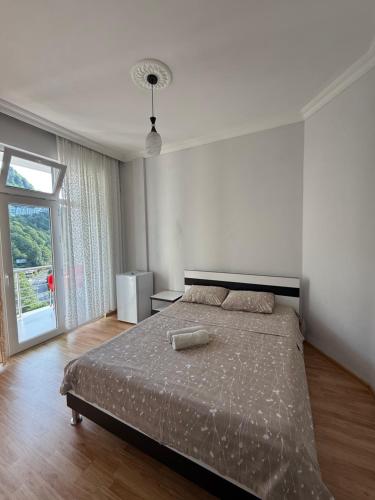 una camera da letto con un letto e una grande finestra di Temo's guest house in Kvariati a Kvariati