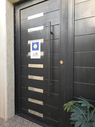 a black garage door with a sign on it at شقة فخمة غرفتين وصالة متكاملة قرب لافاندا بارك in Abha