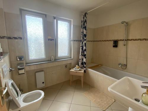 a bathroom with a toilet and a tub and a sink at Penthouse at Cologne Cathedral in Cologne