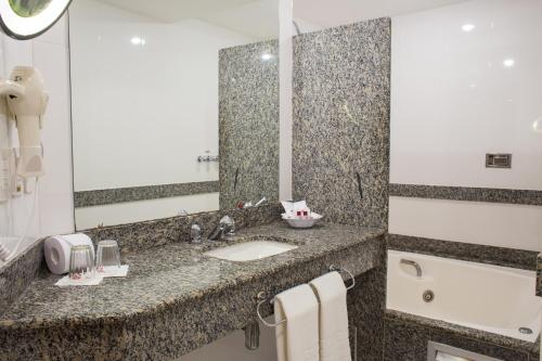 a bathroom with a sink and a mirror at Scorial Rio Hotel in Rio de Janeiro
