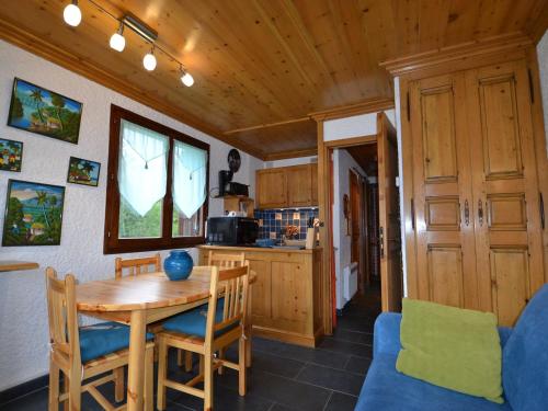 une cuisine avec une table et des chaises de salle à manger en bois dans l'établissement Studio cosy avec balcon, près des pistes au Mont Rond - FR-1-505-37, à Notre-Dame-de-Bellecombe