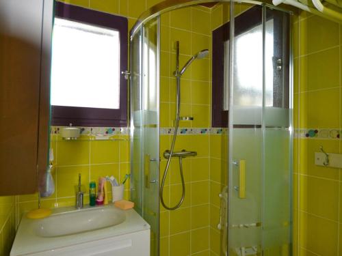 La salle de bains jaune est pourvue d'une douche et d'un lavabo. dans l'établissement Studio cosy avec balcon, près des pistes au Mont Rond - FR-1-505-37, à Notre-Dame-de-Bellecombe