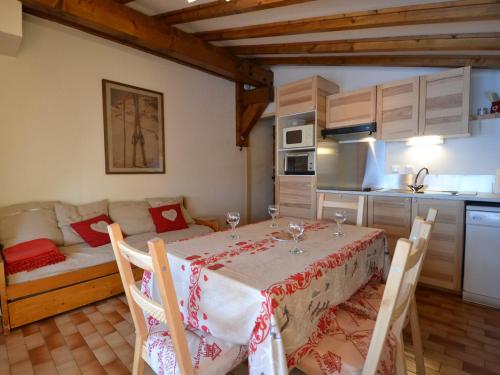 Un comedor con una mesa y una cocina. en Charmant appart 4/5 pers au pied des pistes avec balcon, Wifi, parking, animaux OK - FR-1-505-65, en Notre-Dame-de-Bellecombe