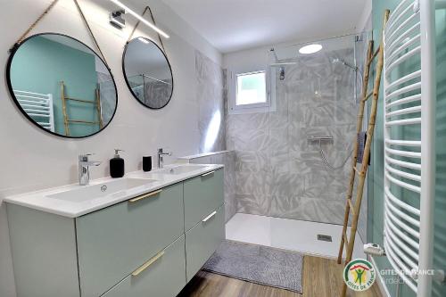 une salle de bain avec un lavabo et une douche avec un miroir dans l'établissement Villas Nature et liens, à Saint Alban Auriolles