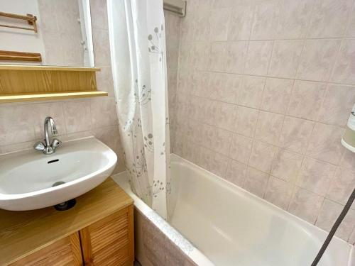 une salle de bain blanche avec un lavabo et une baignoire dans l'établissement Charmant studio au pied des pistes, animaux admis - FR-1-505-79, à Notre-Dame-de-Bellecombe