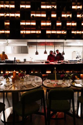 a restaurant with two tables and people in the kitchen at ONOMO ALLURE ABIDJAN BAOBAB in Abidjan